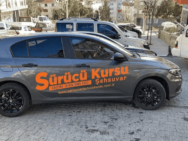 Şehsuvar sürücü kursu yazılı gri aracın yandan görüntüsü