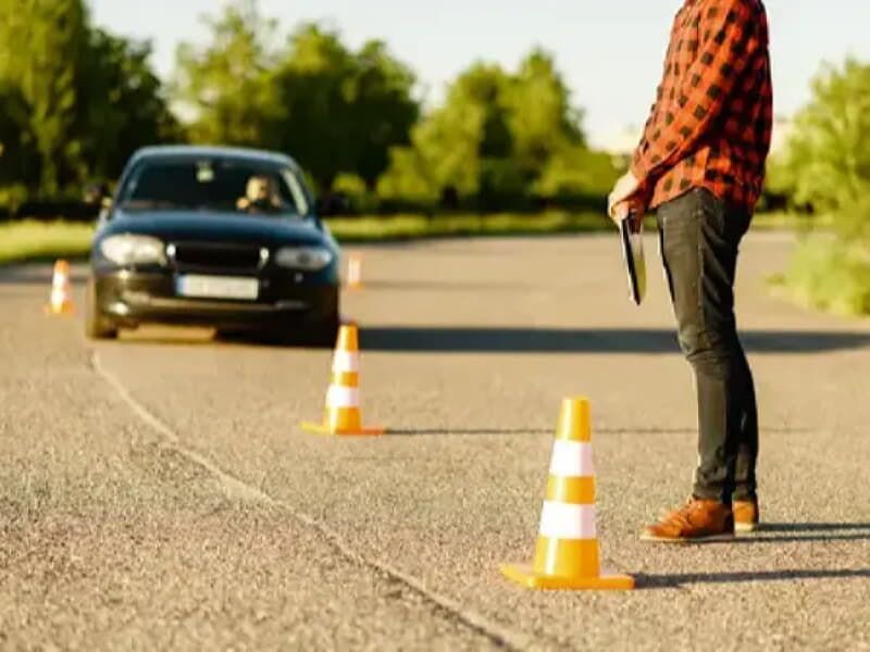 dizilen dubaların yanında bekleyen biri ve gelen bir araç